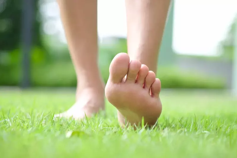 Person walking on grass with bare feet