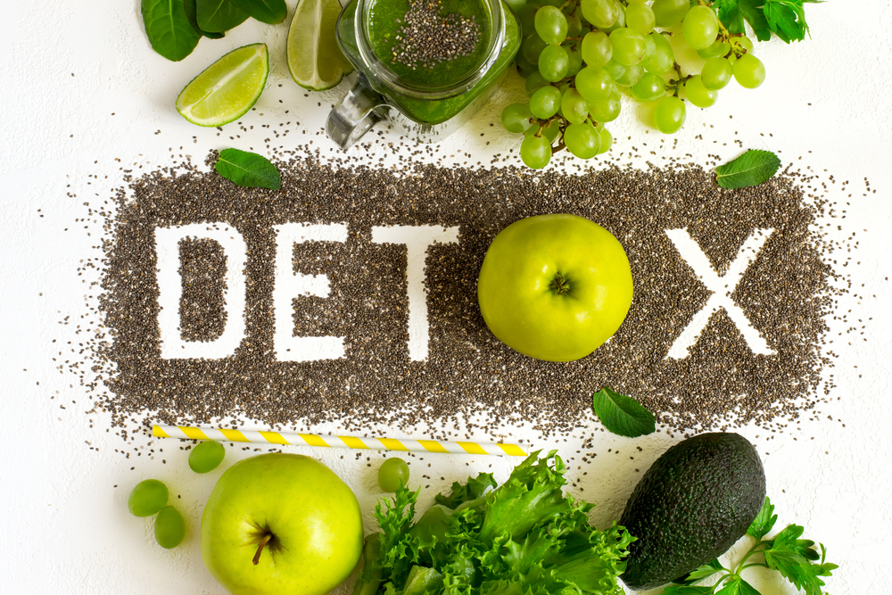 detox spelled out in chia seeds surrounded by fruits and vegetables