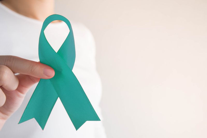 person holding cervical cancer ribbon
